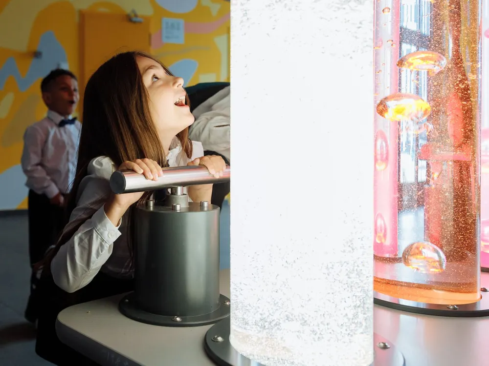 Children engaging with a colorful interactive science-museum exhibit